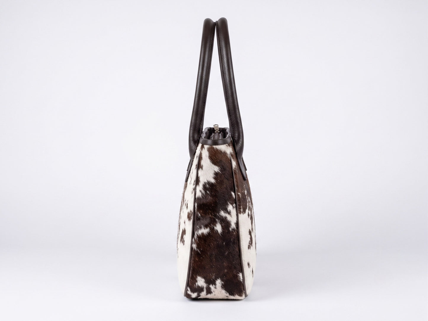 Side view of the Hashmeers hair-on cowhide ladies purse showing dark brown leather piping