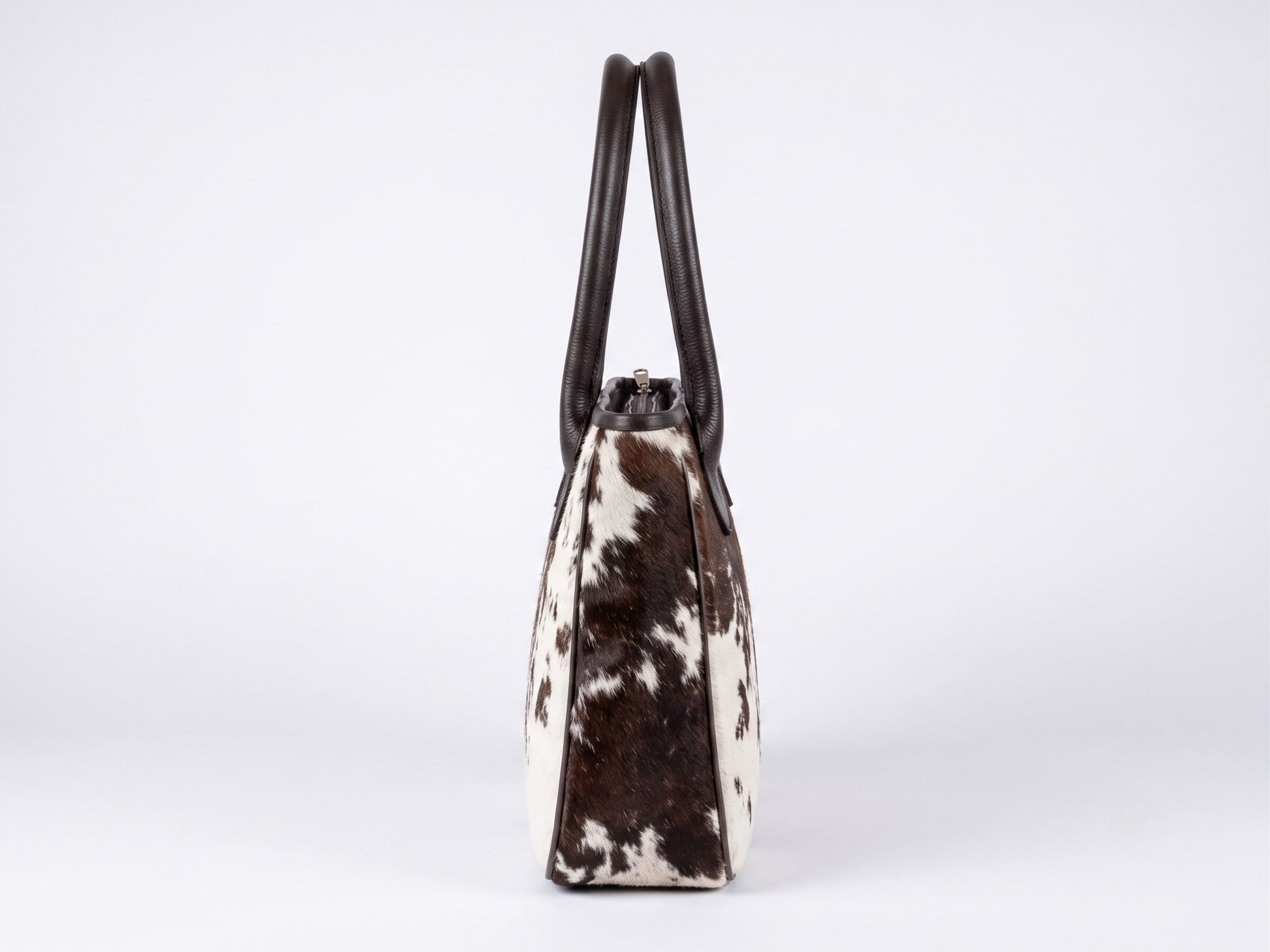 Side view of the Hashmeers hair-on cowhide ladies purse showing dark brown leather piping