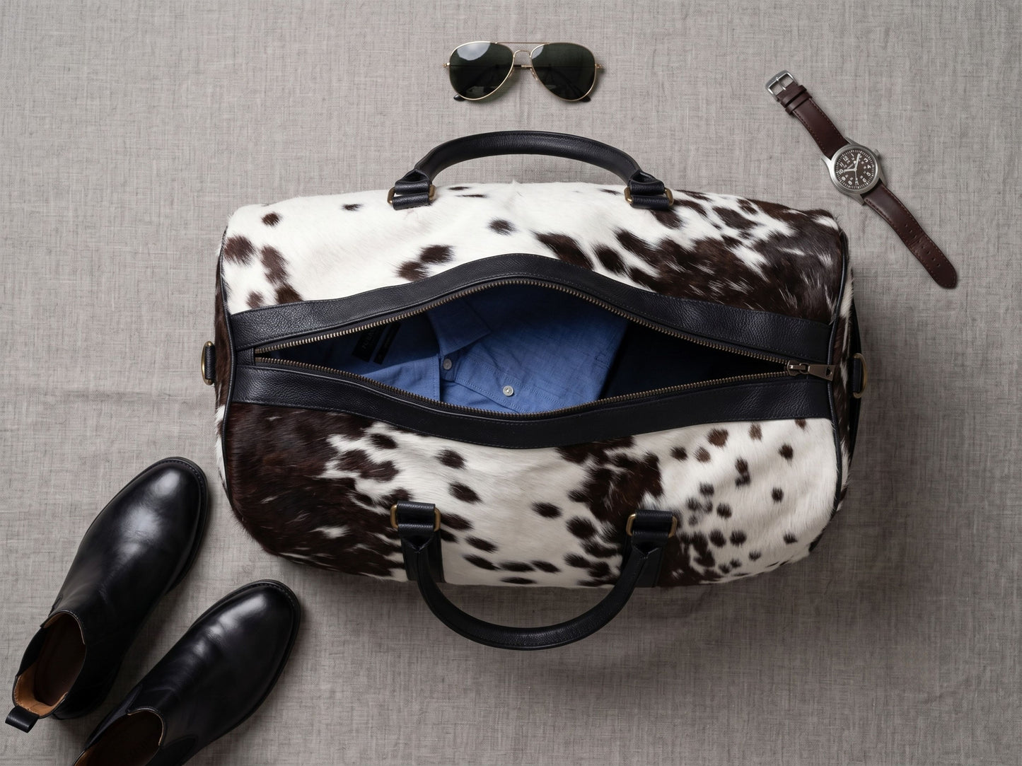 Branded antique brass twin zip pulls on the Hashmeers hair-on cowhide weekender